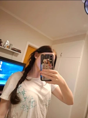 Vit t-shirt med svärdtryck - Vit t-shirt med unikt grönt tryck av ett stort svärd och text på ryggen samt dekorativa detaljer framtill. T-shirten har korta ärmar och en klassisk passform. Perfekt för dig som gillar coola och annorlunda motiv.