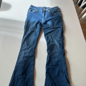 Blå low flare jeans med låg midja - Säljer ett par snygga blå jeans med låg midja och utsvängda ben. Dem är inte i det klassiska jeans materialet utan mycket skönare att ha på sig och sitter inte åt. Är 162 lång och dem är perfekta i längden. 