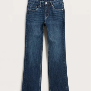Blå jeans med kontrastsömmar låg midja - Låg midjade jeans.Säljer ett par blå jeans med vita kontrastsömmar och snygga fickdetaljer bak. Byxorna har låg midja, raka ben och justerbar resår i midjan- långa i benen jag är 168 . Klassisk femficksmodell i jeansmaterial, perfekta för en avslappnad look.