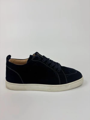 Mörkblå Louboutin sammetssneakers - Snygga mörkblå sneakers i sammet med vita sulor och matchande mörkblå skosnören. Klassisk låg modell med rund tå och diskreta sömmar för en clean look. Insidan är ljus och ger en schysst kontrast till utsidan.