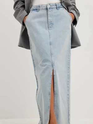 Ljusblå lång jeanskjol med slits - Trendig ljusblå långkjol i denim med hög midja och en snygg slits framtill. Klassisk femficksmodell och raka linjer ger en clean look. Perfekt att styla med sneakers eller boots för en cool vardagsstil.