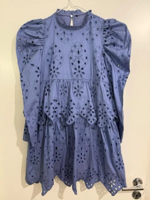 Zara classic Ljusblå broderad kortklänning - Supersöt ljusblå kortklänning med puffärmar och broderade spetsdetaljer. Klänningen har rund halsringning, knäppning bak i nacken och vackra hålbroderier över hela plagget. Perfekt för dig som gillar romantisk och unik stil.