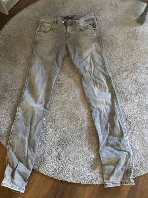 Grå slim fit jeans från Jack & Jones - Snygga grå slim fit jeans från Jack & Jones med klassisk femficksdesign och knappgylf. Jeansen har en tvättad look och raka ben. Perfekta för en avslappnad och trendig stil.