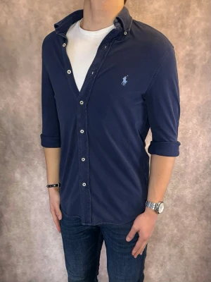 Marinblå Ralph Lauren Skjorta - Stl S, FeatherWeight Mesh  - RIKTIGT FET RL SKJORTA I FÄRGEN MARINBLÅ, perfekt till sommaren som närmar sig! 🏖️🌊 |Mycket bra skick: 9,5/10, utan defekter! | Stl: S |  Modellen är 176cm och väger 75kg,  | Hör av dig vid frågor // Galgen 🫡