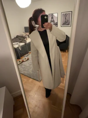Ljusbeige kappa  - En super fin beige kappa från Zara. Storlek xs. Aldrig använt så super fint skick. Band vid midja så man kan knyta 🥰