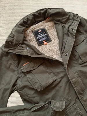 SUPERDRY FIELDJACKET - En mycket trevlig fieldjacket av märket Superdry i en extremt snygg grön färg! Hör av dig vid frågor!