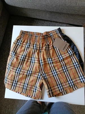 Burberry shorts - Säljer ett par klassiska rutiga shorts från Burberry i beige. Skicka bud.