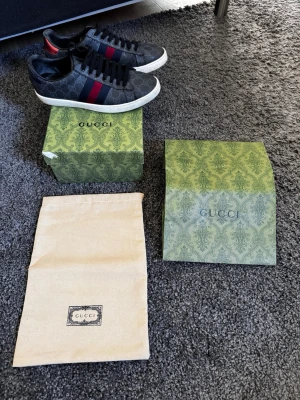 Svarta Gucci ace sneakers - Ett par riktigt feta Gucci ace skor i skick 8/10. De är sparsamt använda men defekter på hälen syns på de sista två bilderna. Dustbag, påse och box tillkommer vid köp av skorna. 