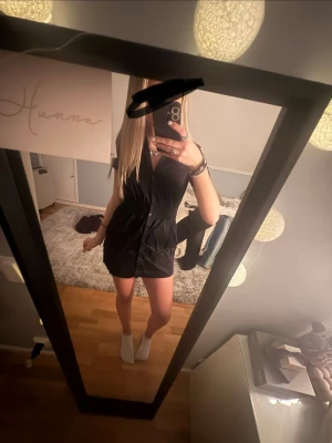 Svart kortärmad kort klänning - Snygg svart kort klänning med v-ringning och knappar framtill. Klänningen har en markerad midja och korta ärmar. Från H&M i storlek 36