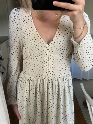 Beige långklänning med svarta prickar - Midi klänning från Monki 