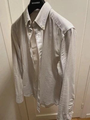 Randig skjorta från East West - En randig skjorta som är beige och vit, använt 3 gånger och är mycket bra skick inga skador eller så, om du har fler frågor så är det bara säga till☺️