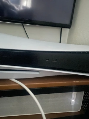 Sony PlayStation 5 konsol - PlayStation 5 konsol med futuristisk design i vitt och svart. Konsolen har en slimmad, kurvig form och är tillverkad i plast. Utrustad med USB-portar på framsidan och skivläsare. Perfekt för gaming på nästa nivå. Kommer med alla tillbehör så som kontroll laddare, sladdar, stativ, låda, en kontroll (den på bilden) och kanske något mer 