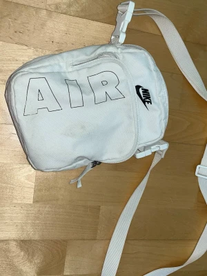 Laukku - Valkoinen niken laukku. Muuten vielä hyvässä kunnossa, mutta etutaskun vetoketju revennyt. Hihnan saa myös pois nipsuilla. Pitkä ja säädettävä hihna. Isomman taskun sisällä pienempi tasku. Koko noin 15x24x6cm. Eläintalous MMM Katsothan myös muut ilmoitukseni Tarjoa 