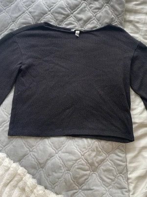 Svart stickad tröja från H&M - En enkel svart stickad tröja från H&M i storlek S. Tröjan har rund halsringning, långa ärmar och en rak, något kortare passform. Perfekt att matcha med jeans eller kjol för en clean look.