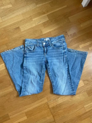 Gina tricot | Young  - Säljer dessa jättefina blå lågmidjade jeans från GinaTricot Young💕 De är flare Jeansen har fem fickor varav 2 y2k liknande bakfickor✨ De har resårband vilket gör det lättare att justera till sin egen storlek😊 Använt några gånger så de har lite slitna ändar men annars i mycket gott skick!💗 Storlek:152   Pris går att diskutera😄 Hör av dig om du har några frågor!