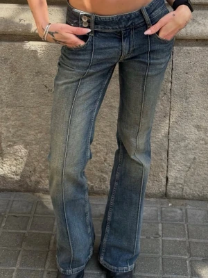 Blå bootcut jeans med pressveck ZARA - Snygga blå bootcut jeans med markerade pressveck framtill och låg midja. Jeansen har klassisk femficksdesign och stängs med knapp och dragkedja. Perfekta för en trendig och avslappnad look. 