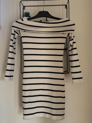 Randig ribbad offshoulder klänning - Vit svart randig offshoulder klänning i storlek Xs