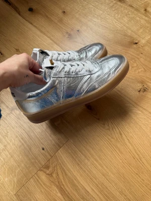 MJUS silver sneakers viral storlek 39 belt nye - Endast provade en gång, i nyskick. Storlek 39. Nypris 1700 kr, säljes billigt.