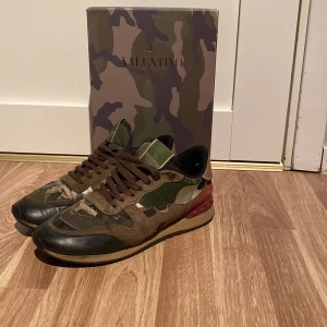 Valentino Rockrunner - Snygga Valentino Rockrunner sneakers i ett coolt camouflage-mönster. Skorna har en mix av gröna, bruna och svarta nyanser med snörning och en bekväm sula. Perfekta för en stilren och avslappnad look.