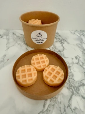 Vaniljdoftande vaxkakor från Candelle - Säljer handgjorda vaxkakor med vaniljdoft från Candelle Handmade. Kakor i ljus beige färg, runda med rutmönster, levereras i brun pappersburk. Perfekta för att smälta i doftbrännare och sprida en söt vaniljarom hemma.