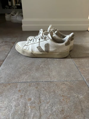 Vita Veja sneakers med beige detaljer - Snygga vita sneakers från Veja i storlek 39 med beige detaljer på häl och logga. Passar även de med storlek 40