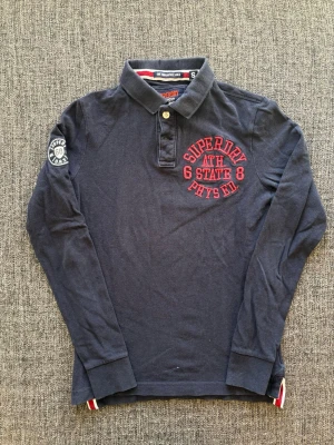 Superdry longsleeve ~ vintage  - Sjukt sällsynt Superdry longsleeve i marinblå – stl S.  Modellen är väldigt sällsynt och produceras inte längre därav ökad efterfrågan🙌 Fint skick och sitter riktigt bra ✌️ Kan även gå ner lite i pris vid snabb affär Skickas inom 24h 📦