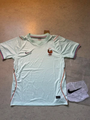 Ljusblå Nike fotbollströja Frankrike - Säljer en helt ny Frankrike VM 2026-tröja – storlek S. 🇫🇷  Helt ny och oanvänd. Bekväm passform och stilren design utan namn eller nummer på ryggen.  Information:  * Storlek: S * Helt ny och oanvänd * Ingen spelare eller nummer på ryggen * Bekväm passform  Skickas eller hämtas enligt överenskommelse. Hör gärna av dig vid frågor!