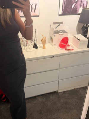 Grå tight långklänning - Säljer en grått sett med tight passform och ärmlös design. Setter har en enkel och stilren look som framhäver figuren. Perfekt för dig som gillar minimalistisk stil och vill ha en klänning som känns både modern och klassisk.