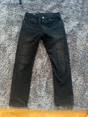 Levi’s 501 - Ett par svarta levi’s 501. Jeansen är använda ett antal gånger och färgen är nött på framsidan som går att se på bilden. Utöver det finns inga defekter. Strl 30/30. 