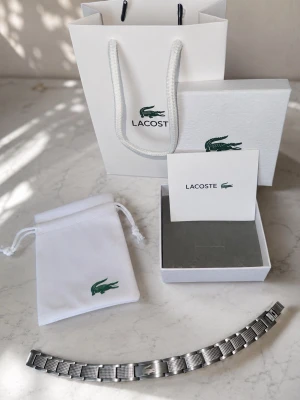 Lacoste armband - Lacoste armband i rostfrittstål. Går st tillägga till samt ta bort länkar som man vill.         Skriv vid frågor!!!