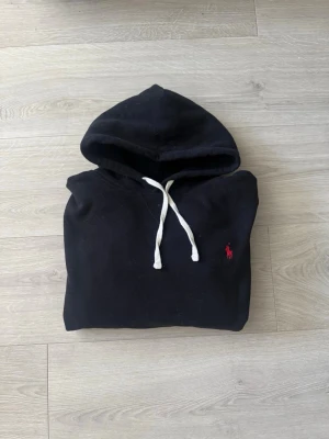 Svart hoodie från Ralph lauren  - Säljer en svart hoodie från Ralph lauren. Storlek L men skulle säga att den passar bättre som M. Tröjan har inga tecken på slitage och är u mycket gott skick