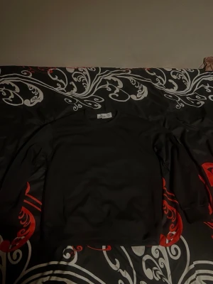 Svart sweatshirt från Stone Island - Säljer en svart sweatshirt från Stone Island med klassisk rund halsringning och långa ärmar. Tröjan har en stilren och enkel design utan tryck eller mönster, perfekt för en clean look. Materialet känns mjukt och bekvämt mot huden.