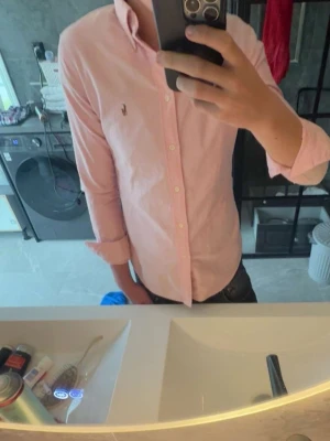 Rosa Ralph lauren skjorta  - Säljer en fett skjorta från ralph lauren färg rosa storlek S-mått , armlängd 61 cm mått från axeln , axel till midja 64cm mått från inre axel ner till midjan, yttre axel över bröstkorgen till andra yttre axeln 36cm. Priset är inte fast kom dm vid frågor/ Williams store