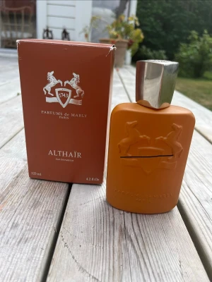 Parfums de Marly Althaïr parfym 125 ml - Parfums de Marly Althaïr Eau de Parfum i en snygg orange flaska med silverfärgat lock. Flaskan har en elegant, matt finish och är dekorerad med två hästar i relief. Kommer med originalkartong i matchande färg. 100ml kvar.