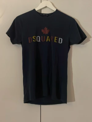 Dsquared2 tshirt - En riktigt fet Dsquared tshirt i mörkblått storlek M( men sitter lite mer som S). Tröjan är i ganska okej skick, inga skador eller så. Riktigt fet pris för denna! O tveka ej att höra av er 🔥🕺