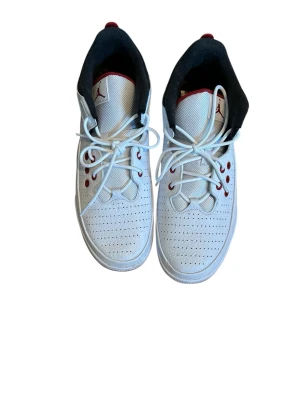 Vita Air Jordan sneakers med röda detaljer - Snygga vita Air Jordan sneakers med perforerad ovandel i mesh och läder, röda detaljer vid snörningen och svart vadderad insida. Klassisk Jumpman-logga på plösen och robust sula för extra komfort. Perfekta för dig som gillar sportig och stilren look.  Ny pris runt 800kr, använda fåtal gånger