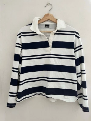 Randig långärmad topp med krage - Blå och vit randig tröja. Har bara lite missfärgning/ sminkfläckar vid kragen men gör säkert att få bort! Annarsbi väldigt gott skick, endast använd enstaka gång