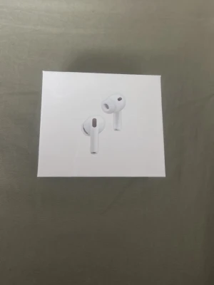 Apple AirPods Pro 3rd Gen med ANC - Trådlösa in-ear hörlurar från Apple, AirPods Pro 3rd Generation, i vit färg. De har aktiv brusreducering och levereras i en stilren, kompakt förpackning. Hörlurarna har en modern design med silikonproppar och laddningsetui.