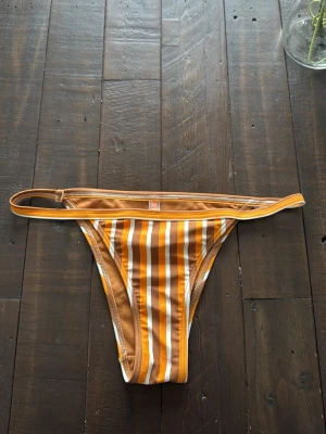 Randig bikiniunderdel  - Snygg bikiniunderdel som aldrig är använd då den inte passar mig. 