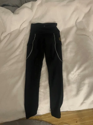 Svarta ridtights från Maya Delorez XS - Snygga svarta ridtights från Maya Delorez. Använda en gång och köpa på Falsterbo horseshow. Färg svart med vita sömar och guldig logga. Säljs till ett bra pris då de nästan inte är använda. I storlek xs