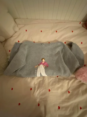 Grå hoodie med tryck 'Fine Line' - Säljer en grå hoodie med Harry Styles på. Hoodien har huva och magficka. Perfekt för dig som gillar coola tryck och avslappnad stil. Snöret till hoodien är dock borta. 