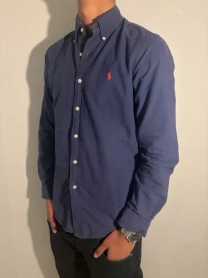 Mörkblå Skjorta från Ralph Lauren - Strl S - Ralph Lauren skjorta 👔✨ Mörkblå och stilren 💙 Storlek S 👀 I fint skick och väl omhändertagen 🔥 Nypris runt 1 400 kr 💸 – vårt pris 399 kr 🔥 Snygg passform som funkar både uppklätt och mer avslappnat 😎 Klassisk och tidlös design Modellen på bild är ca 182 cm och väger runt 65 kg Kolla in profilen för flera skjortor 👀✨ Hör av er om ni har frågor eller vill ha fler bilder 💬