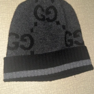 Mörkgrå mössa från Gucci med logga - Sällsynt Gucci mössa som inte säljs längre, oanvänd kommer i nyskick (kvitto finns) nypris på denna mössa ligger runt 6500 kan säljas vid snabbaffär 2,7 pruttat och klart        Möts i Sthlm        Passformen är oversized så skulle säga att den passar L/XL men med en tvätt på kemtvätt så kommer den nog passa den rätta storleken 