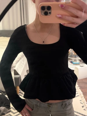 Svart peplum topp  - Svart snygg topp. Köpt från stradivarius! Skulle säga att den är i storlek S! Säljer även en i vit! ❤️