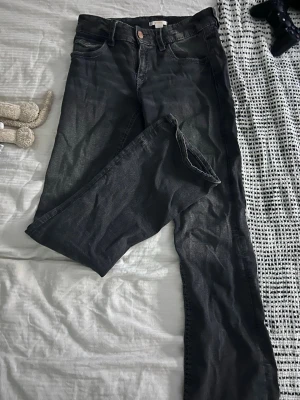 Svarta jeans med bro slog på bakfickor - Säljer ett par svarta jeans med utsvängda ben och snygga broderade detaljer i vitt på bakfickorna. which har klassisk femficksmodell och knappgylf. writes är i ett mjukt denimtyg som passar perfekt till vardagslooken. Jeansen saknar en knapp på en ficka men inget jag tänkt på. 