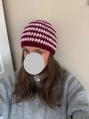 Virkad beanie -  Fin egenvirkad beanie i en hallonröd och ljusrosa färg 💓  Material: 65% alpacka, 28% polyamid, 7% ull  Går att borsta ut om man önskar få den lite fluffig ✨