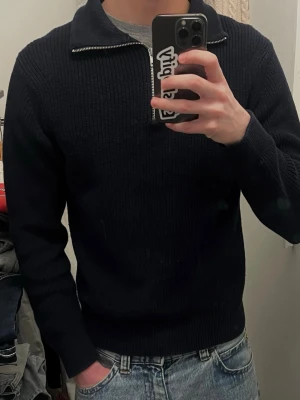 Mörkblå stickad halvzip från East west - Mörkblå stickad tröja från East West med halvzip och bred krage. Cond 9/10, varsamt använd, inga defekter. 