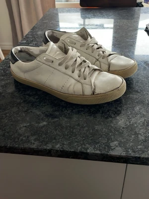 Vita Saint Laurent sneakers - Säljer ett par Saint Laurent skor som inte är i det bästa skicket och där med är priset väldigt lågt! Hör av er vid frågor och funderingar! Pris kan diskuteras!😁