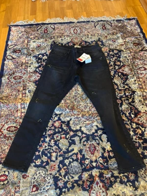 Mörkgråa jeans med färgstänk - Helt nya köptes utomlands men kom aldrig till användning