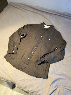 Brun linneskjorta från Ralph Lauren - Säljer en brun långärmad skjorta från Ralph Lauren i linne.✌️ Skjortan har klassisk knappstängning framtill och den ikoniska broderade loggan på bröstet.💯 Perfekt för dig som gillar en avslappnad men ändå stilren look.🥰👍